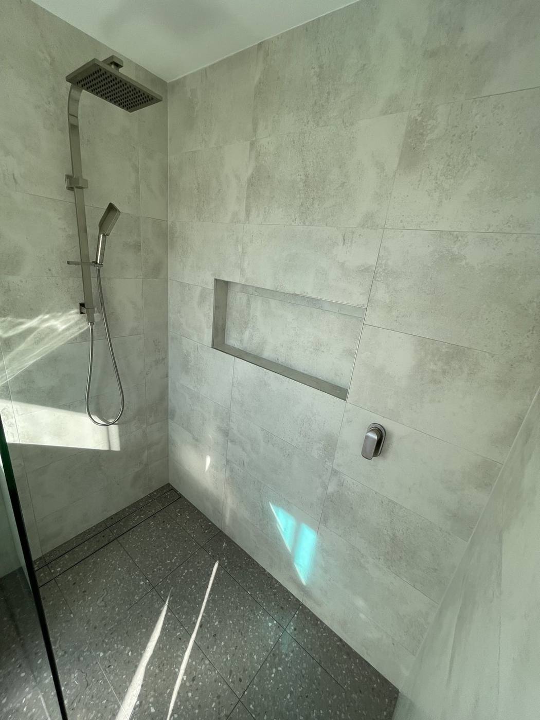 Finished shower detail after renovation with rainfall and handheld shower, mixer and recessed tiled niche, Baulkham Hills by Loel Homes