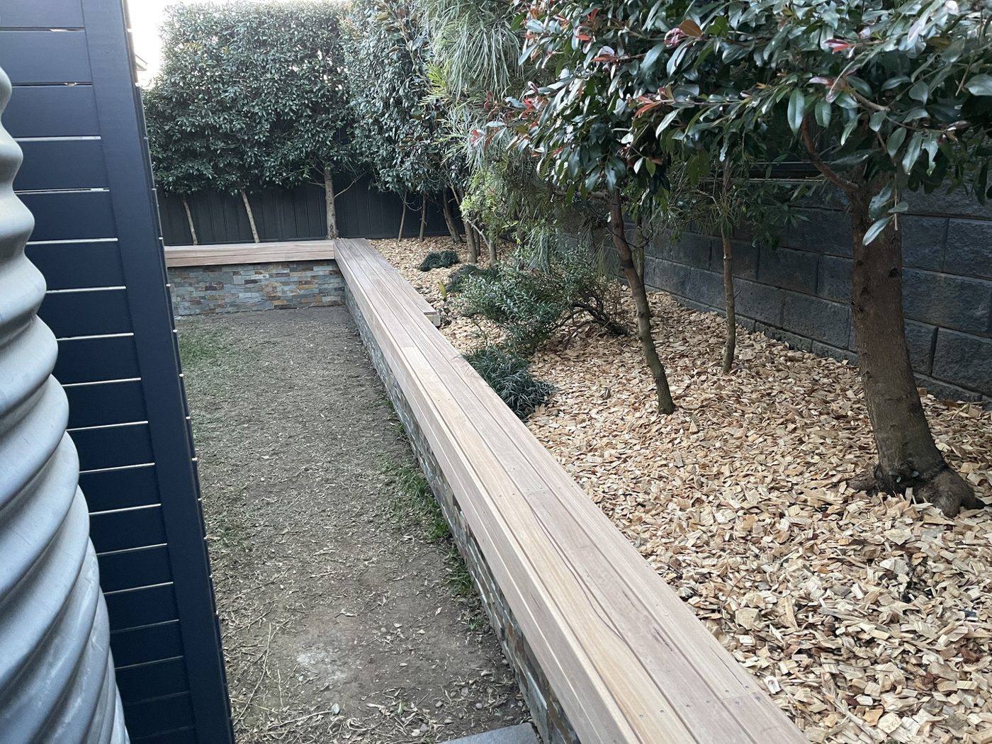 Timber bench sub-frame going in along the corner of the stone planter wall, courtyard by Loel Homes