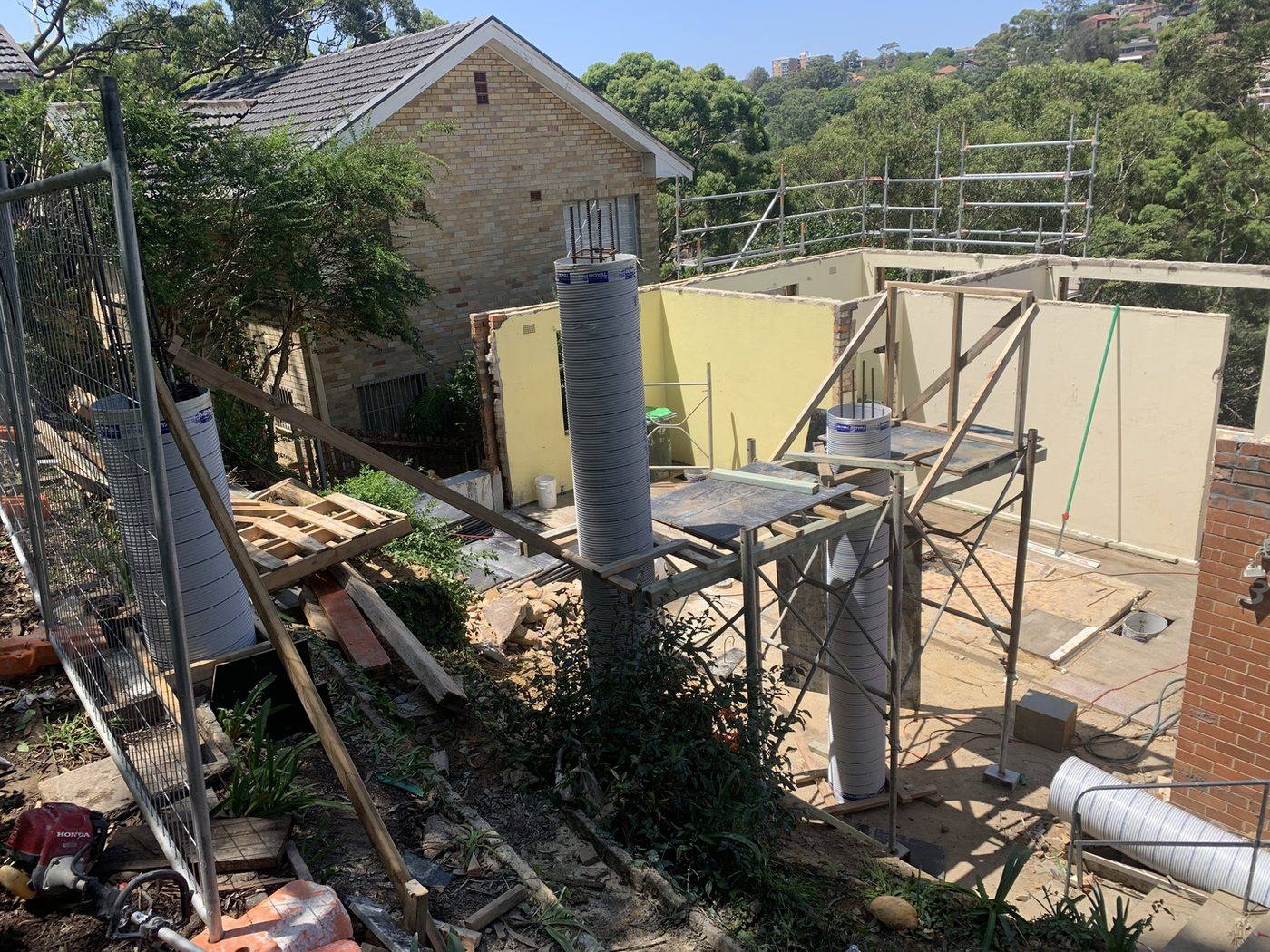 Cardboard column forms braced for concrete piers on a sloping site by Loel Homes
