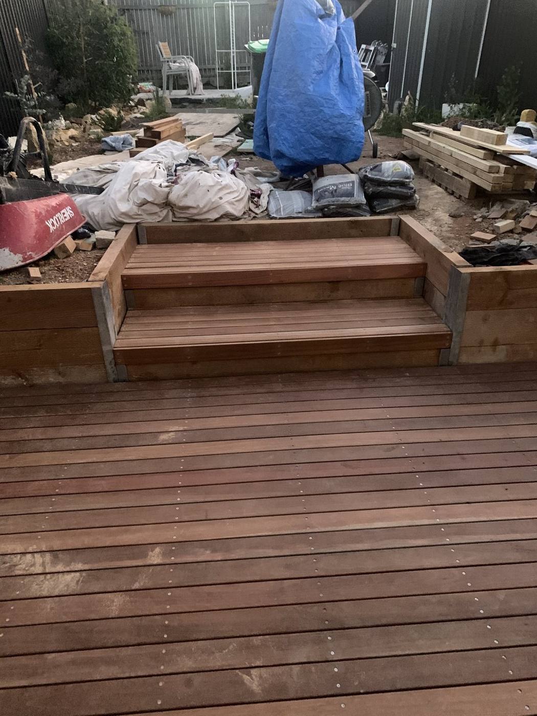 New hardwood deck and steps built off the rear extension with soil, sleepers and landscaping materials still on site, Dulwich Hill by Loel Homes