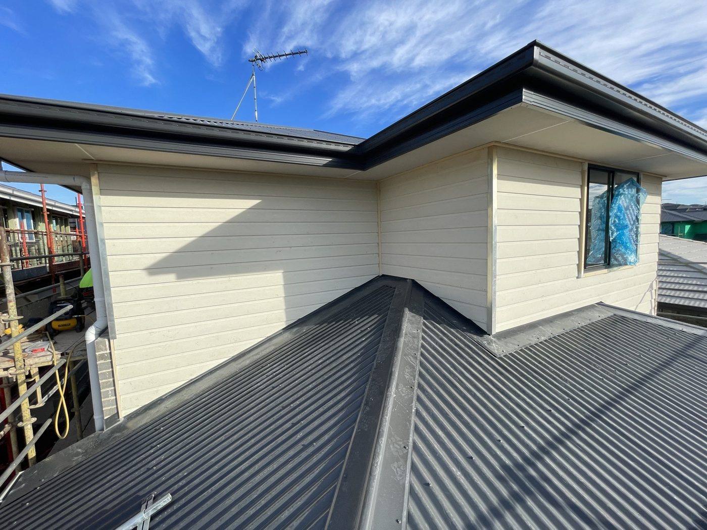 Finished upper-level corner clad and painted cream above the metal roof, double-storey home by Loel Homes