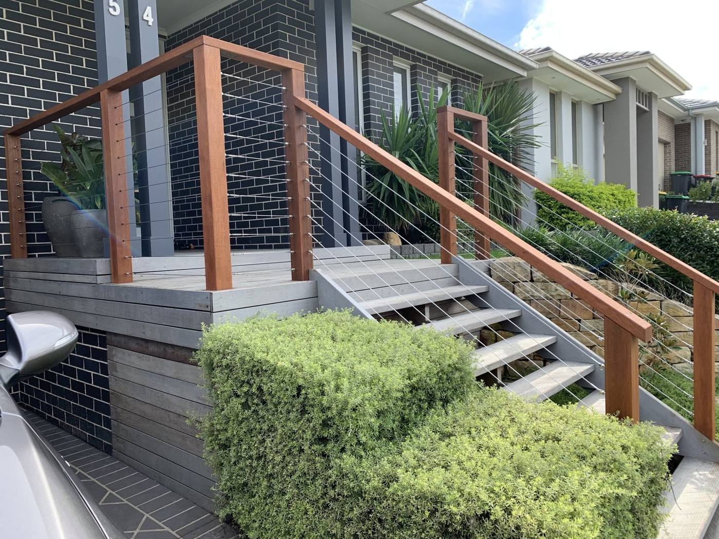 Finished timber and stainless wire balustrade wrapping the entry landing and steps by Loel Homes