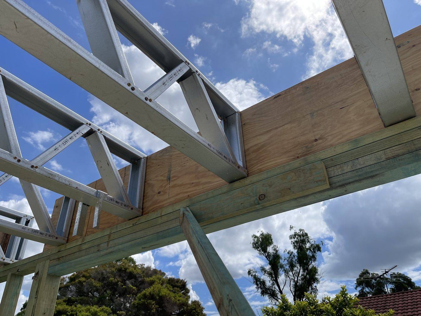 Structural steel beam supporting timber roof trusses on a two-storey new build by Loel Homes