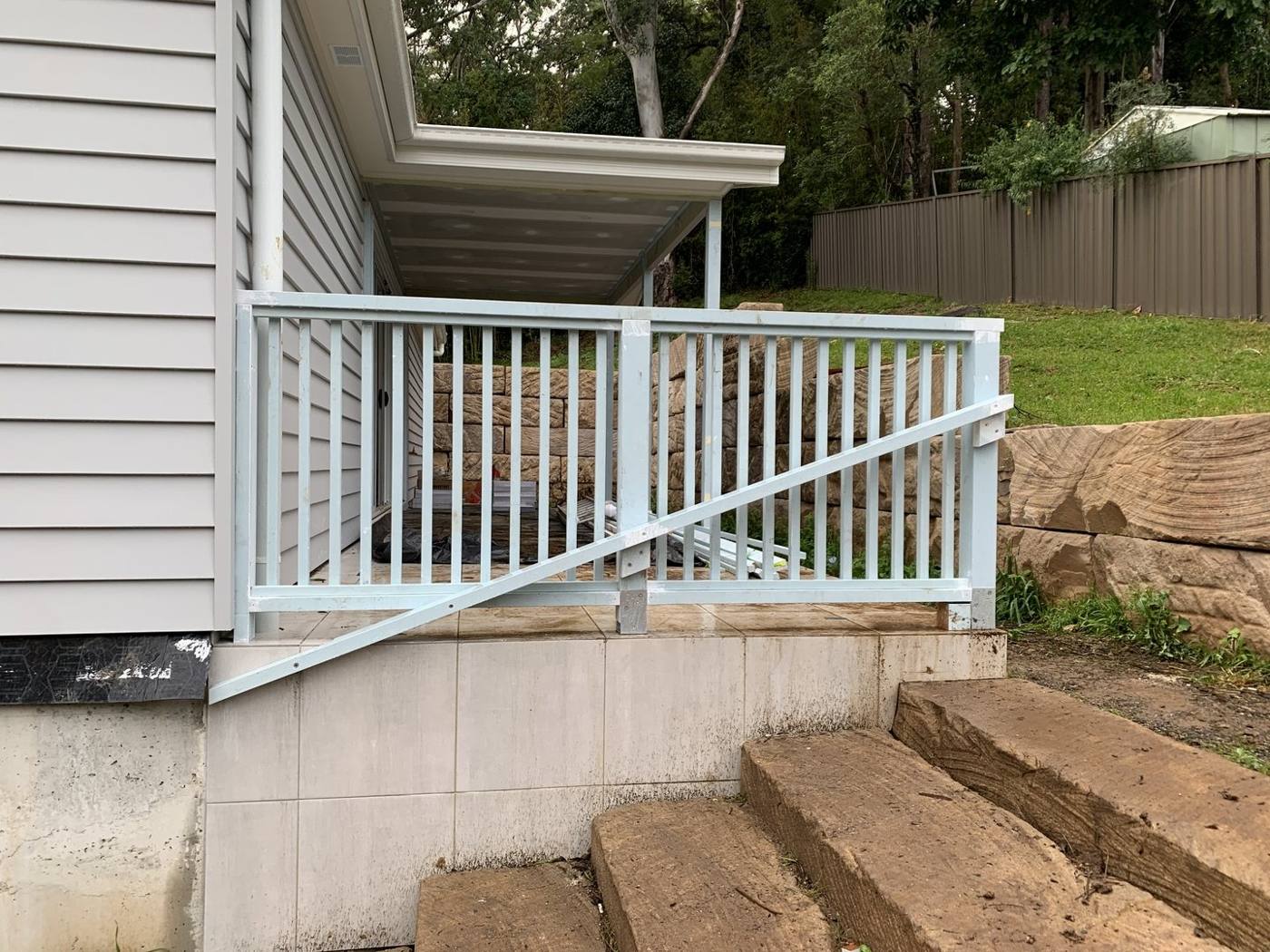 Stone-block garden steps set into the slope beside the finished Juliet balcony by Loel Homes