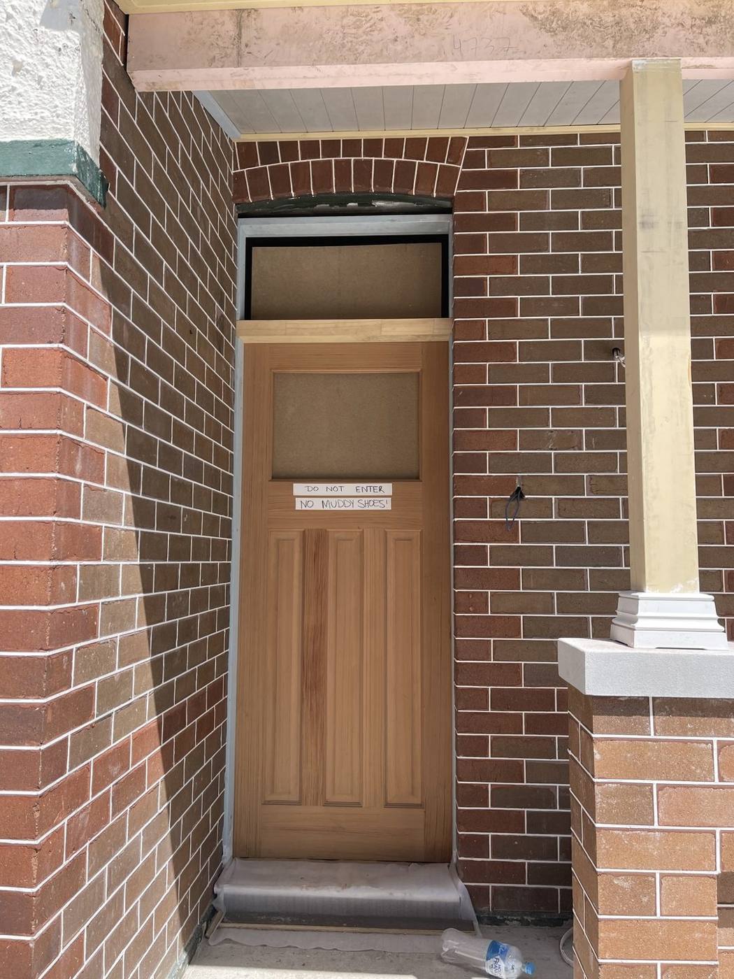 New timber front door hung in the restored brick porch with rendered column, Inner West by Loel Homes