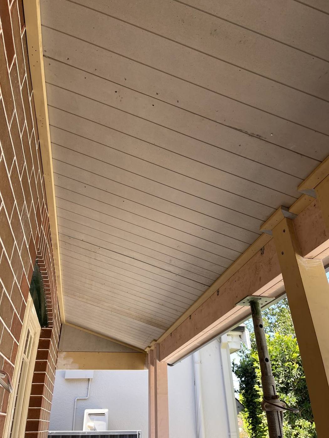 Timber-lined verandah ceiling and soffit running along the brick wall, Inner West carpentry by Loel Homes
