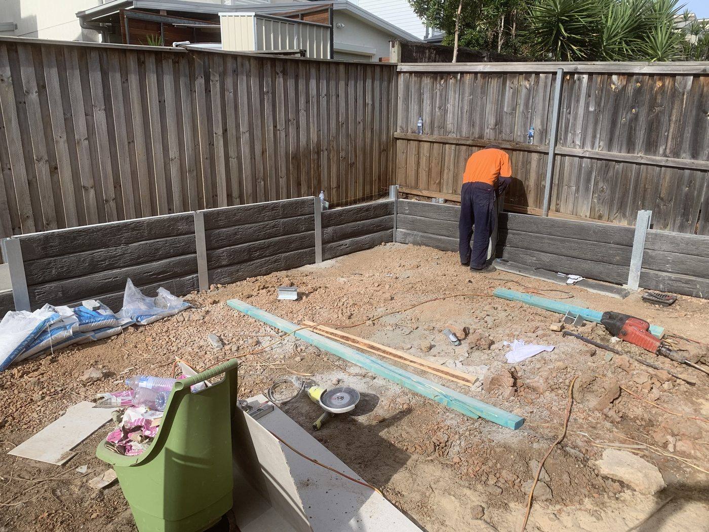 Concrete sleeper retaining wall being installed for a pool by Loel Homes
