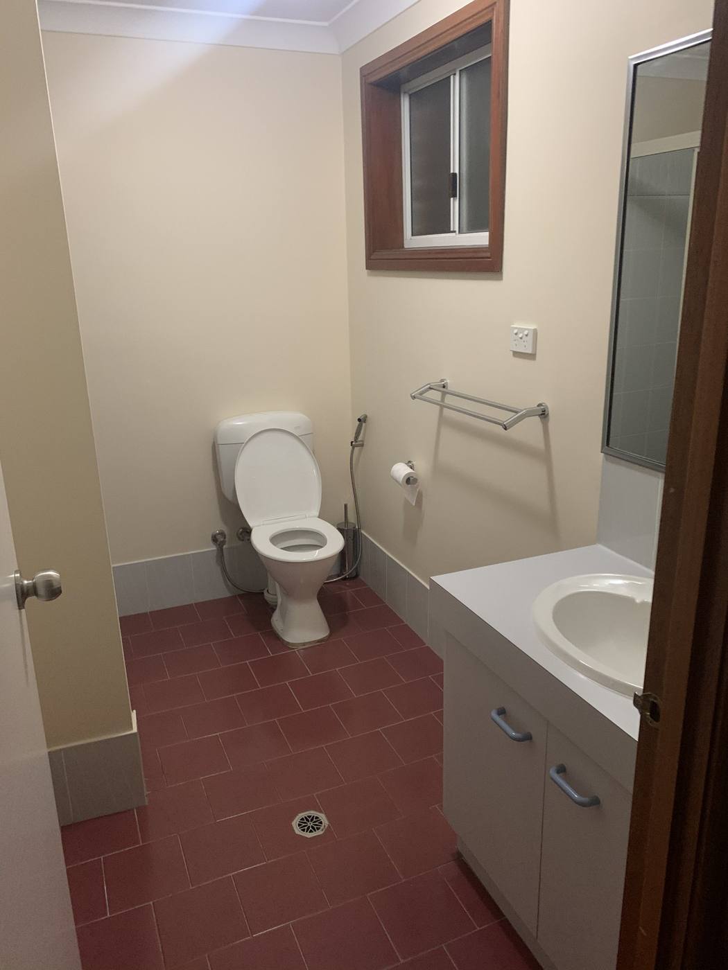 Dated original bathroom before renovation with old toilet, laminate vanity and red terracotta floor tiles, Quakers Hill by Loel Homes