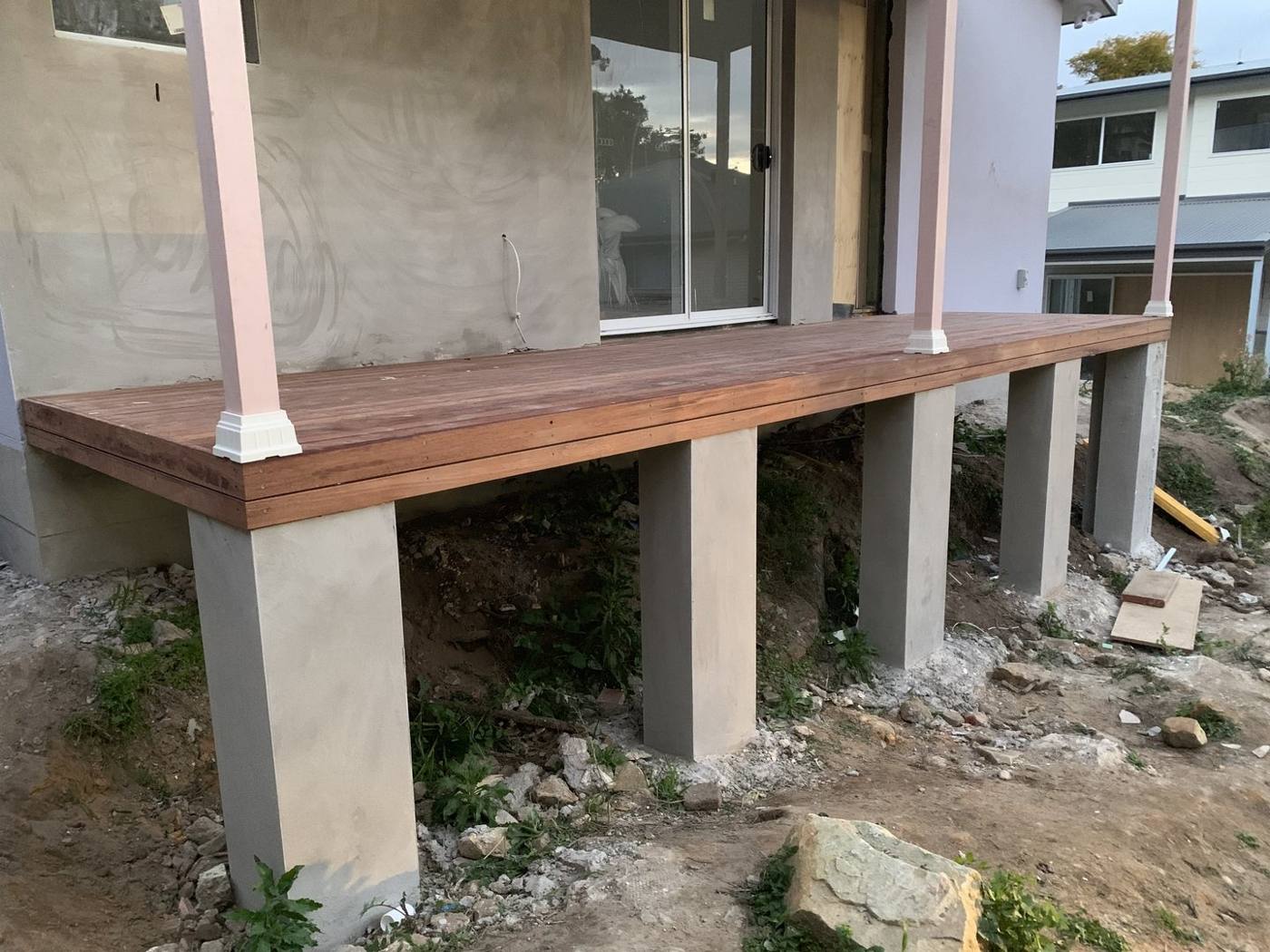Finished raised hardwood deck sitting on rendered concrete piers by Loel Homes