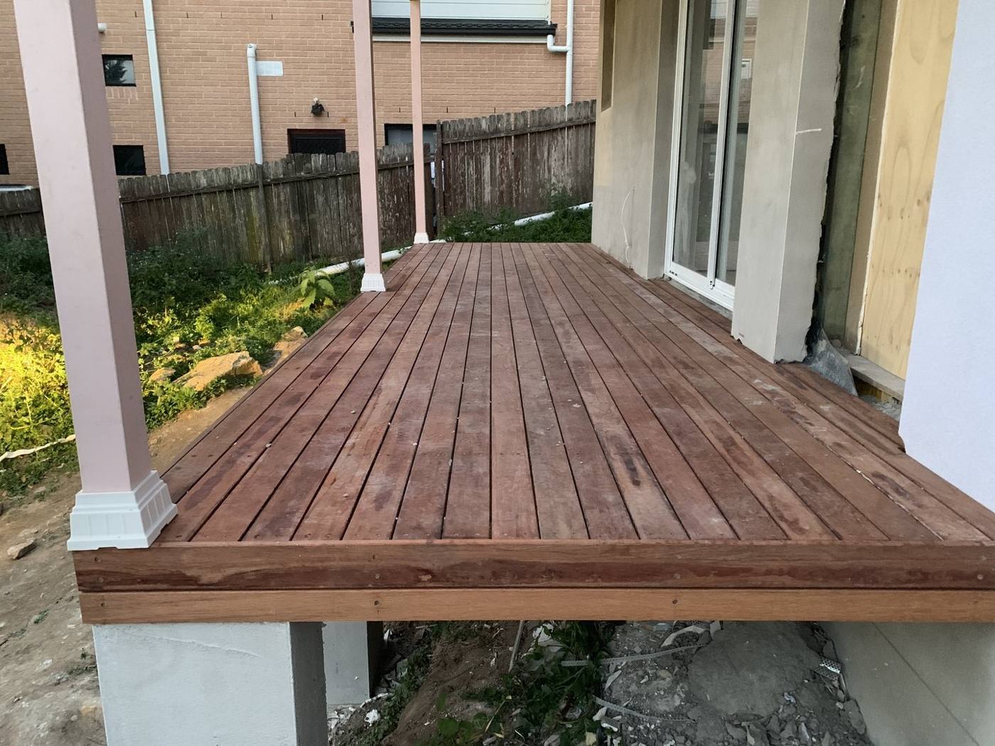 Wide view of the finished raised hardwood deck on rendered piers by Loel Homes