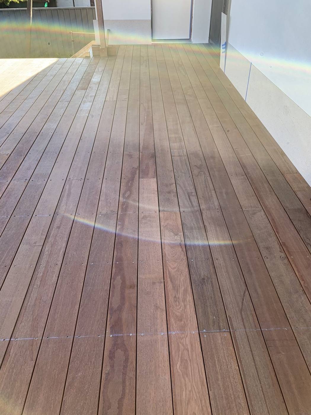 Finished hardwood deck detail meeting the glass door threshold by Loel Homes