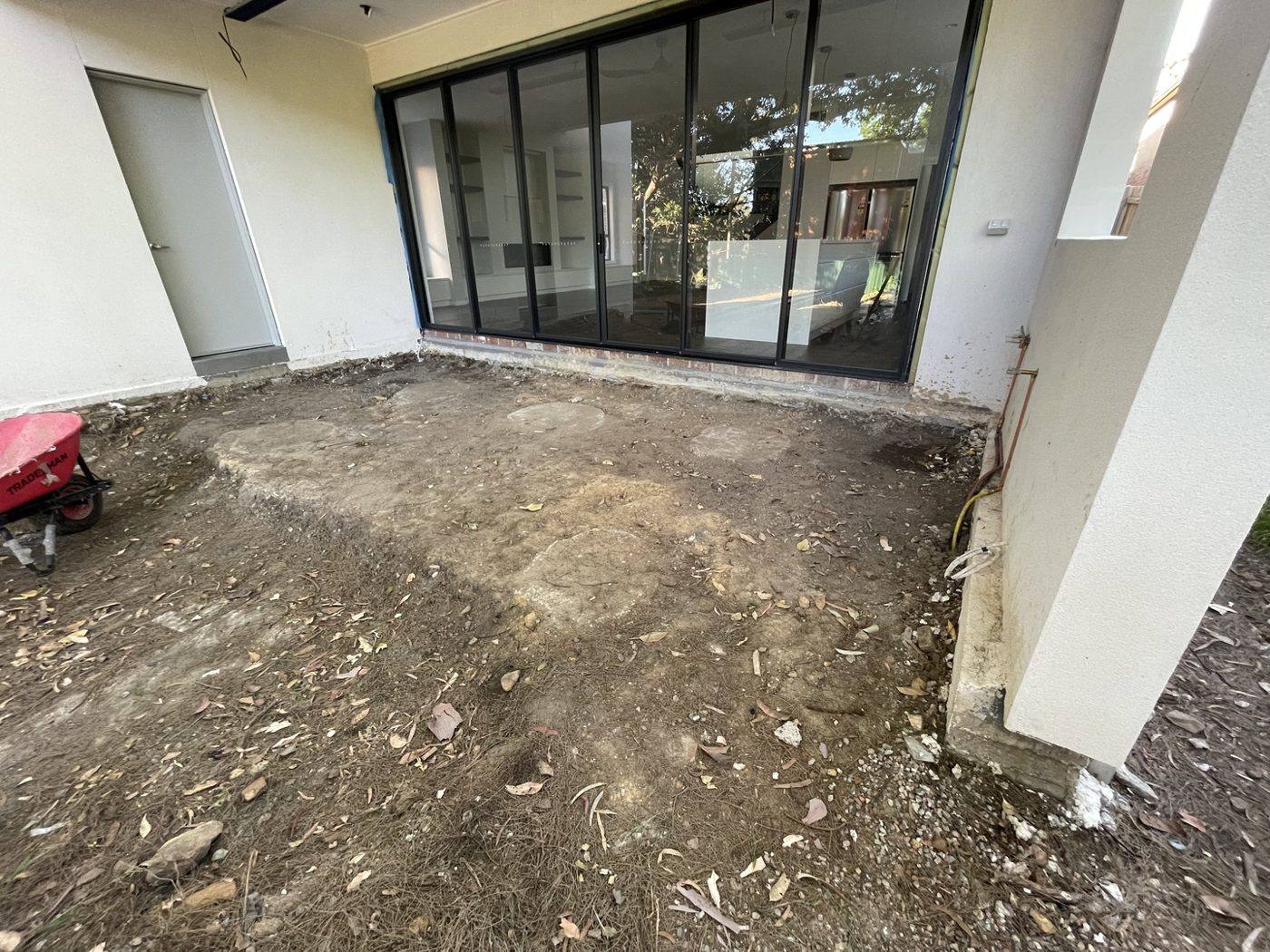 Rear of the home with bare ground below the glass doors before decking by Loel Homes