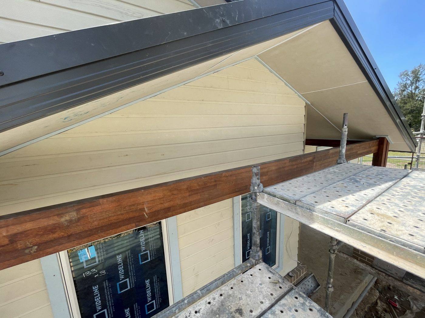 Eave, soffit and window head detail with cladding meeting the roofline and green wrap behind, rural home by Loel Homes