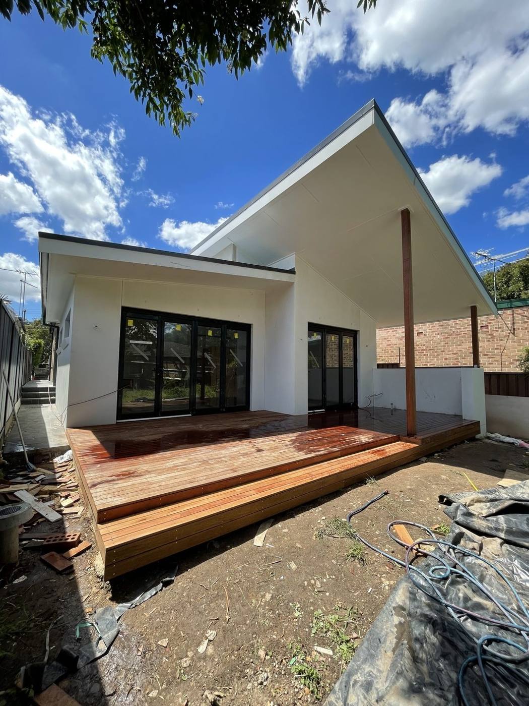 Freshly oiled hardwood deck with wrap-around step under the angled skillion roof, heritage terrace by Loel Homes
