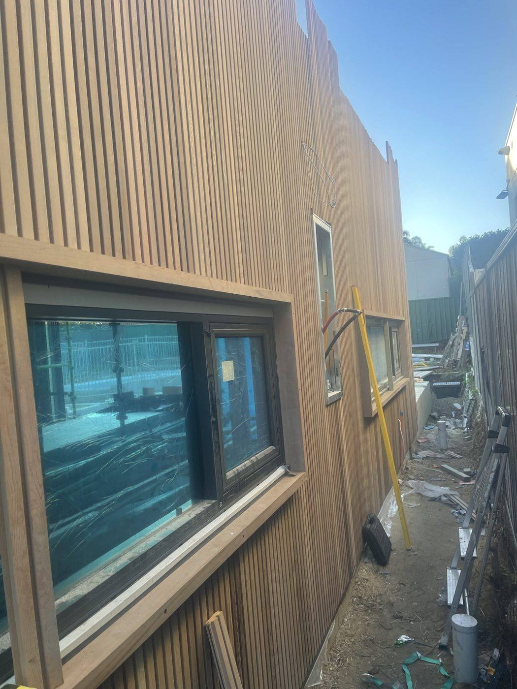 Two-storey side wall clad in pale vertical timber battens with windows, duplex by Loel Homes