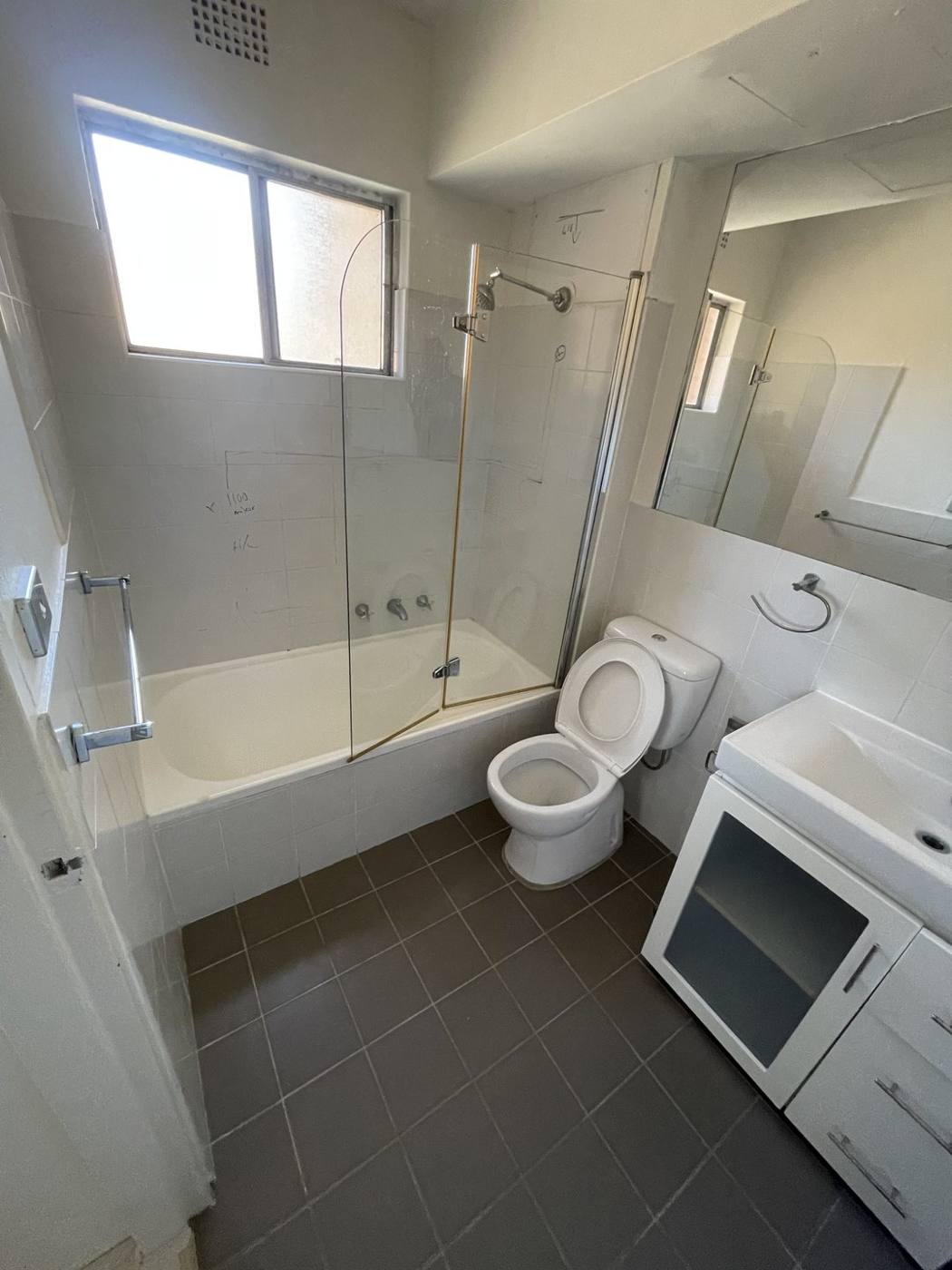 Old bathroom before renovation with bath, framed shower screen and beige wall tiles, Top Ryde by Loel Homes