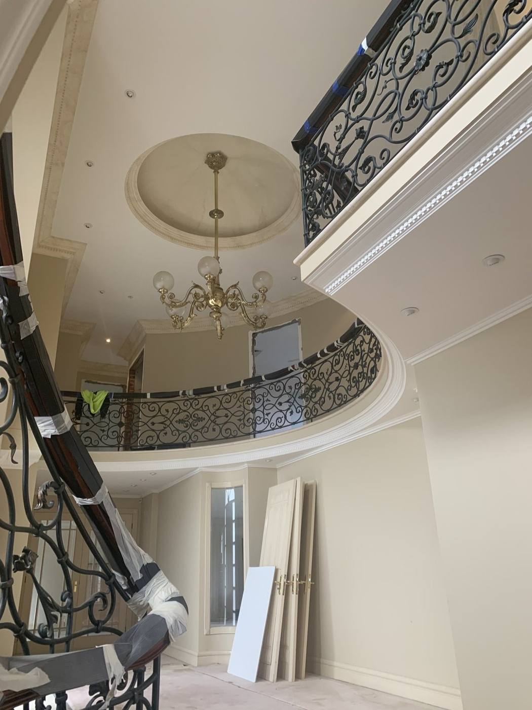 Curved internal balcony void with chandelier and iron balustrade, Vaucluse by Loel Homes
