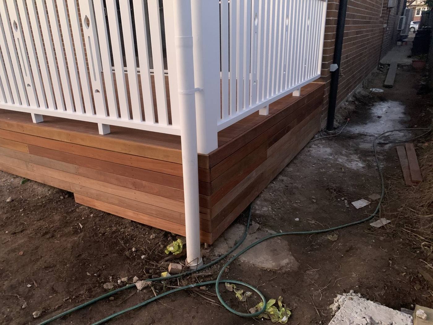 Finished deck with box-clad hardwood skirt below the white balustrade by Loel Homes